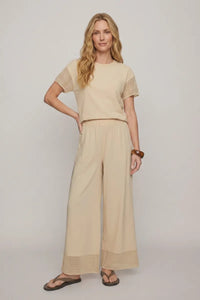 Beige short-sleeved top with mesh detailing paired with banyan crochet relaxed pants for a stylish casual look