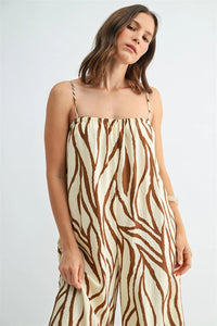 Beige and brown border print jumpsuit with thin spaghetti straps featuring a stylish print design