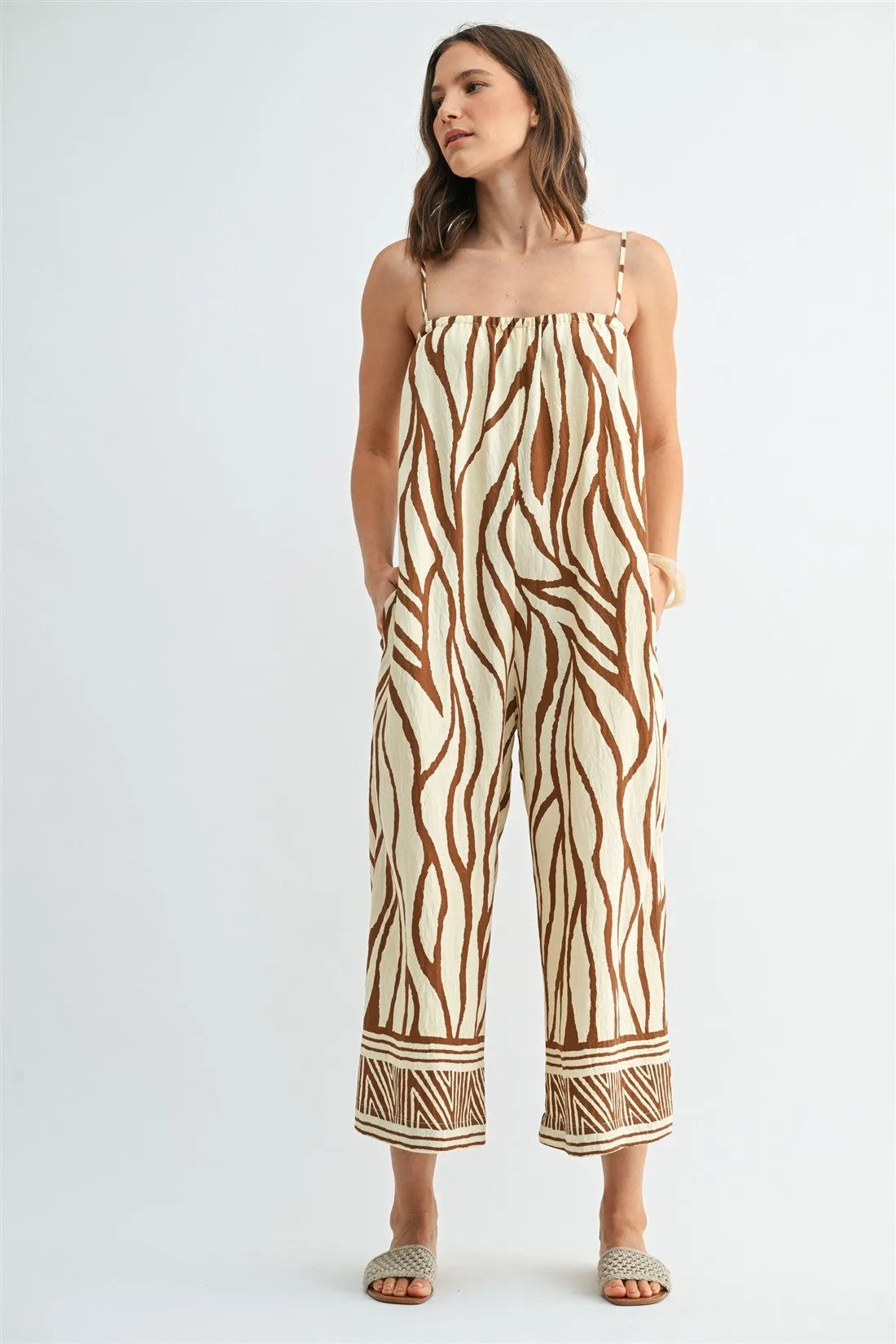 Beige and brown zebra-striped border print jumpsuit with square neckline thin straps and geometric patterned cuffs