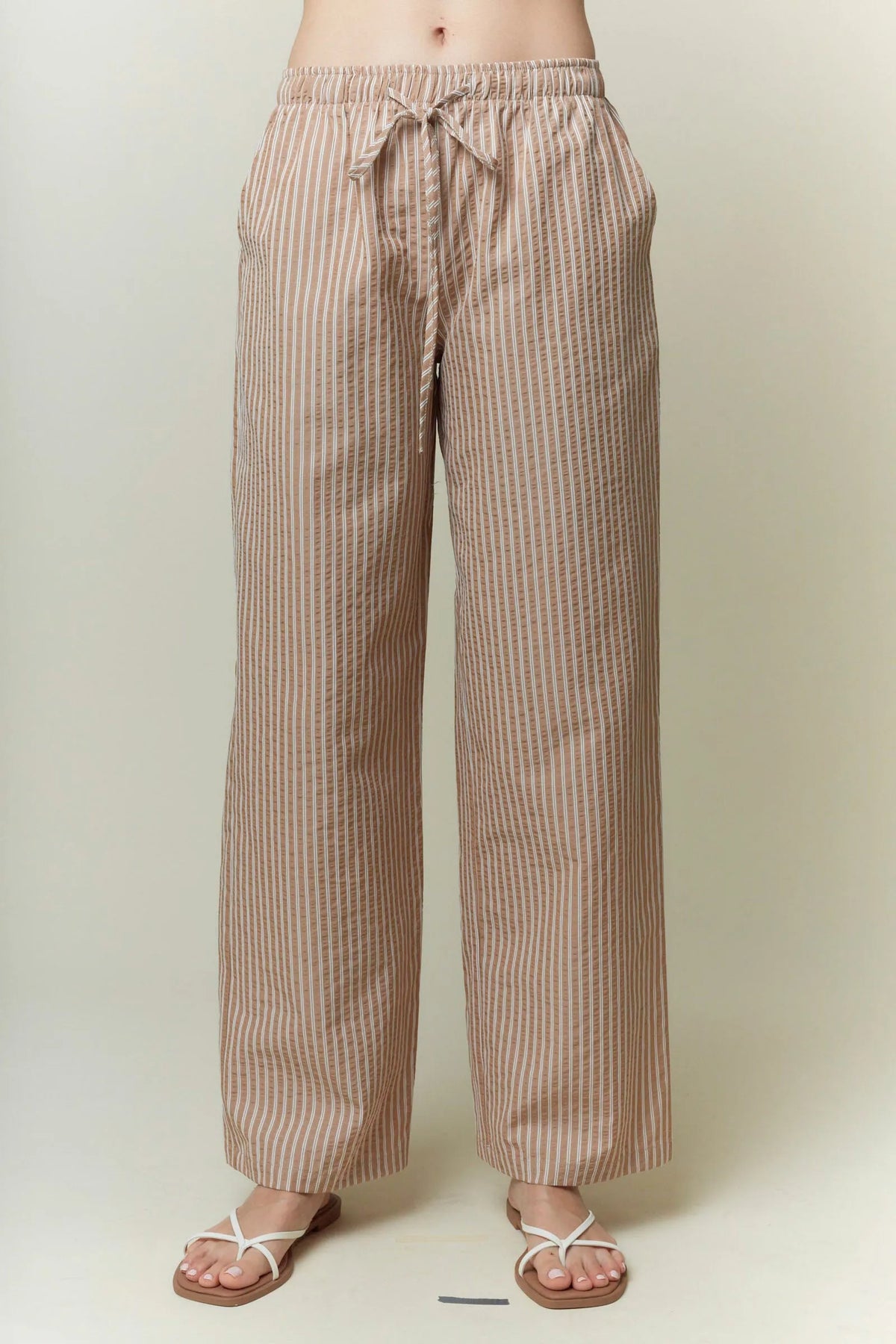 Beige and cream yarn dye stripe elastic pants with wide-leg cut and drawstring waistband for comfortable wear