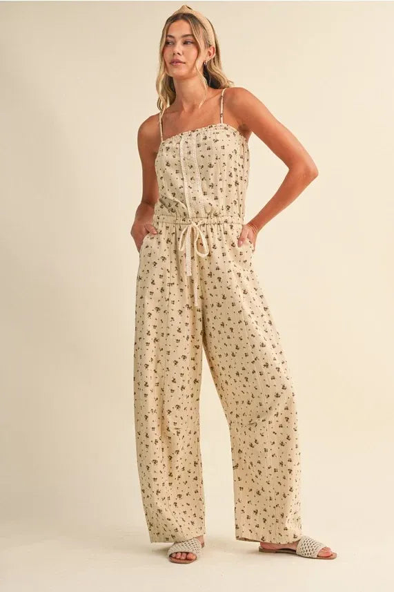 Beige ditsy floral sleeveless lace edge barrel jumpsuit with thin spaghetti straps and a drawstring waist