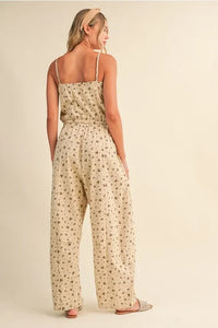 Beige ditsy floral sleeveless lace edge barrel jumpsuit with thin spaghetti straps and relaxed wide-leg silhouette