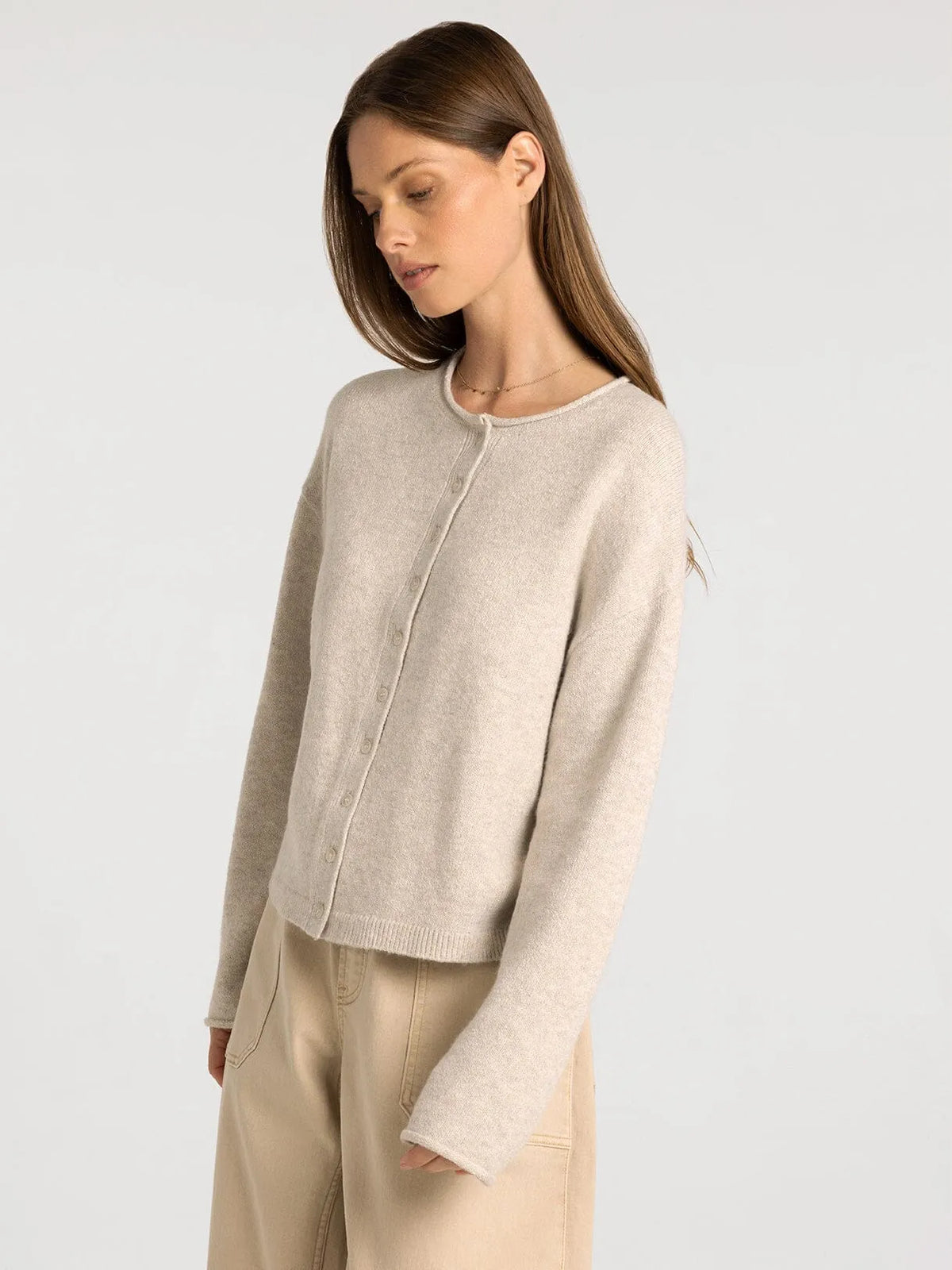 Beige knit cardigan with round neckline and button closure from thread and supply dover button collection