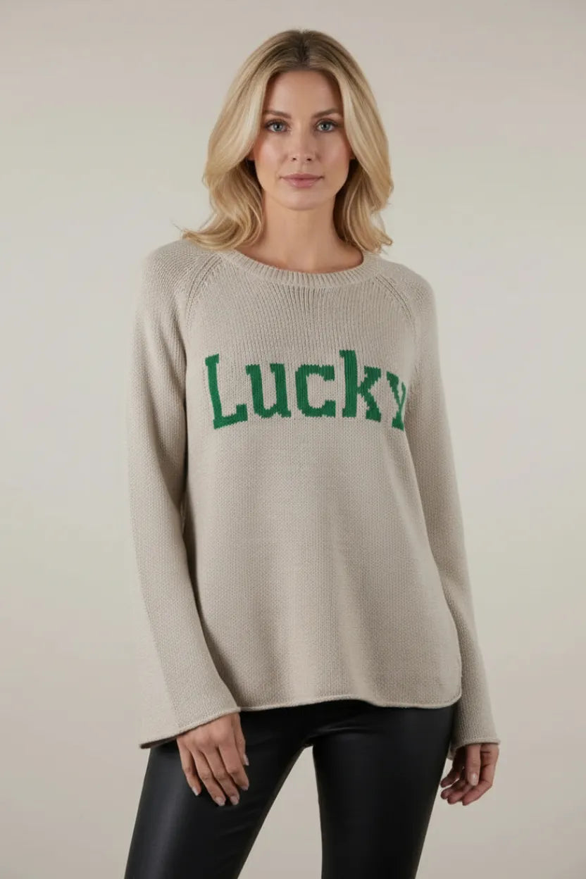 Beige knit long sleeve sweater with green Lucky lettering on chest