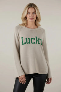 Beige knit long sleeve sweater with green Lucky lettering on chest