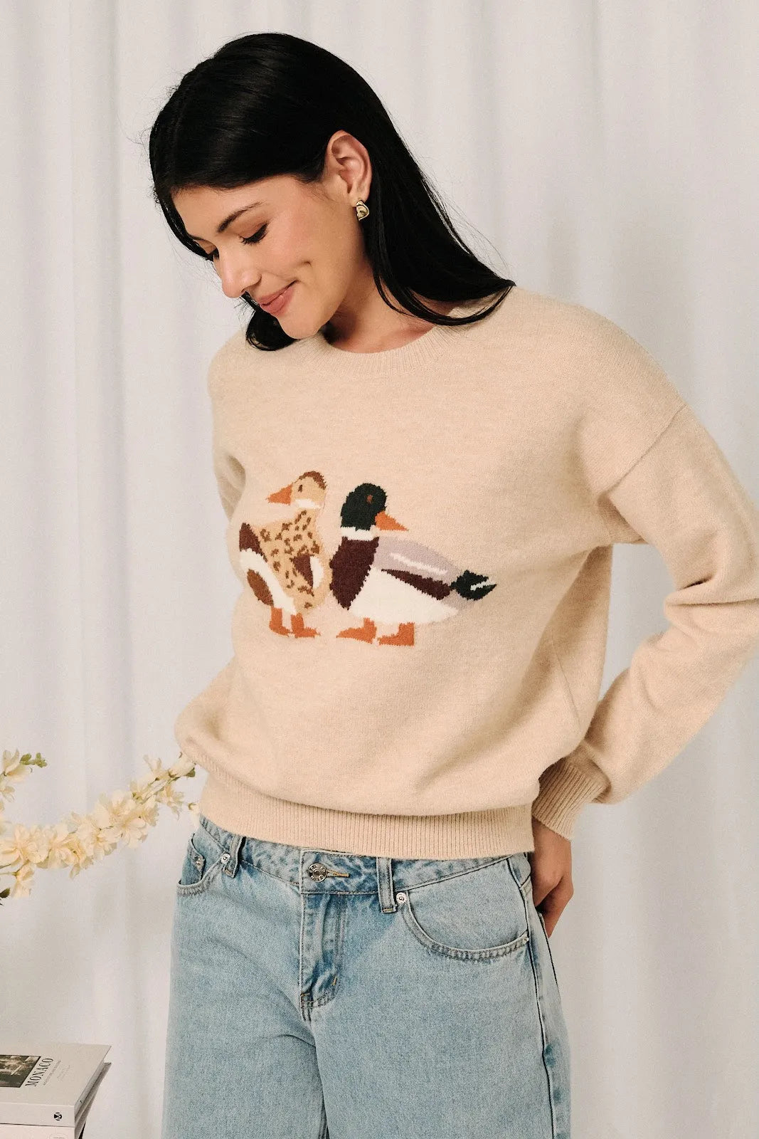 Beige knit sweater featuring a mallard duck graphic embroidered in natural tones on soft knit fabric