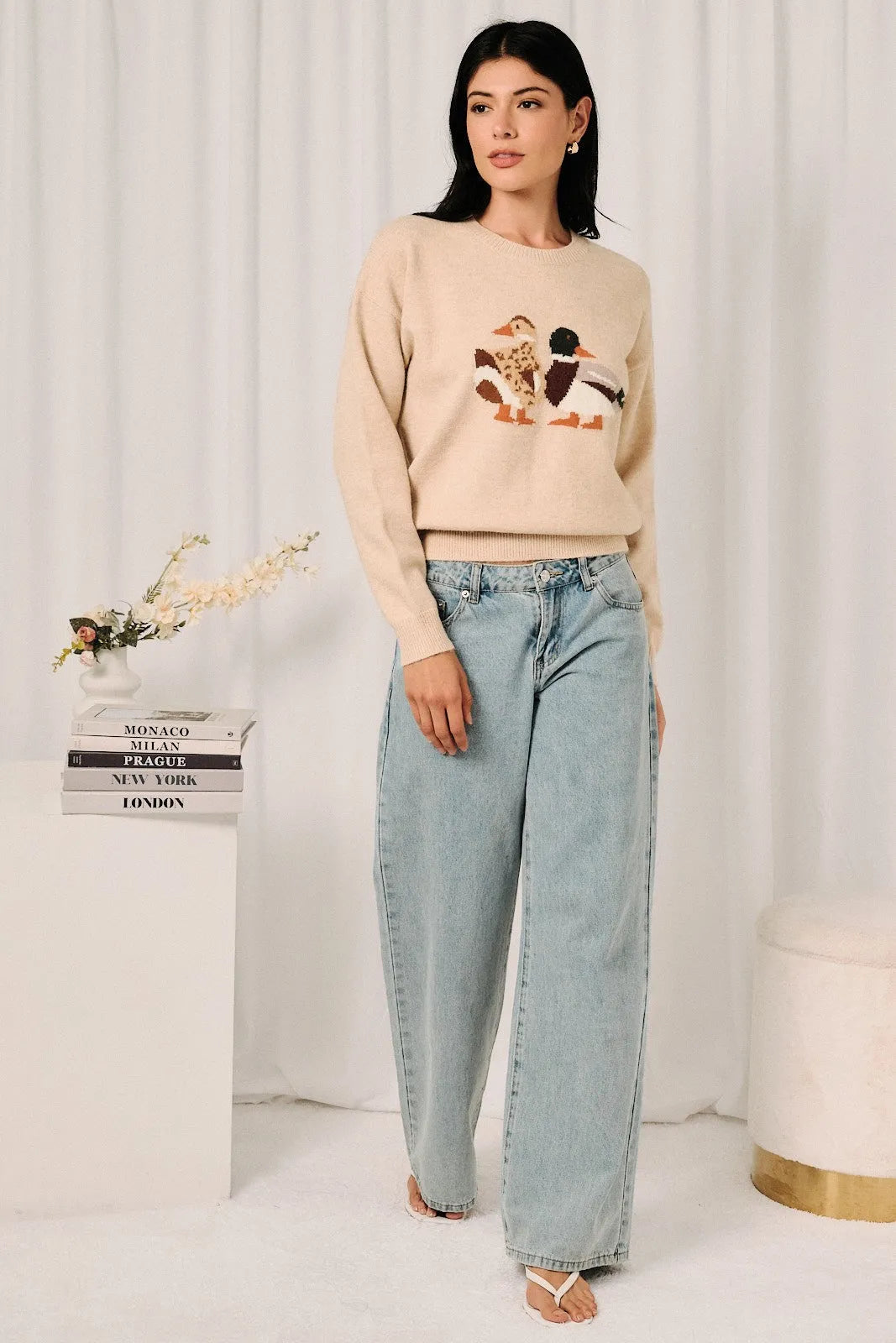 Beige knit sweater featuring a mallard duck graphic embroidered in earthy tones on soft knit fabric