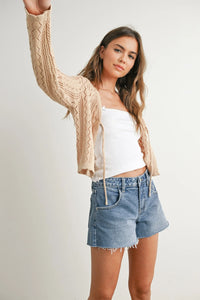 Beige knitted tie-front cardigan with intricate cable-knit pattern