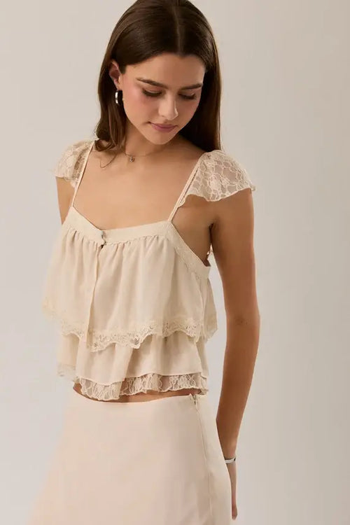 Beige lace trim layered crop top with delicate shoulder straps and ruffled camisole design in lightweight fabric