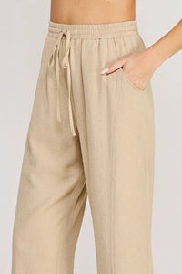 Beige rayon linen blend relaxed tapered pants with a wide-leg cut and side pockets for comfortable wear
