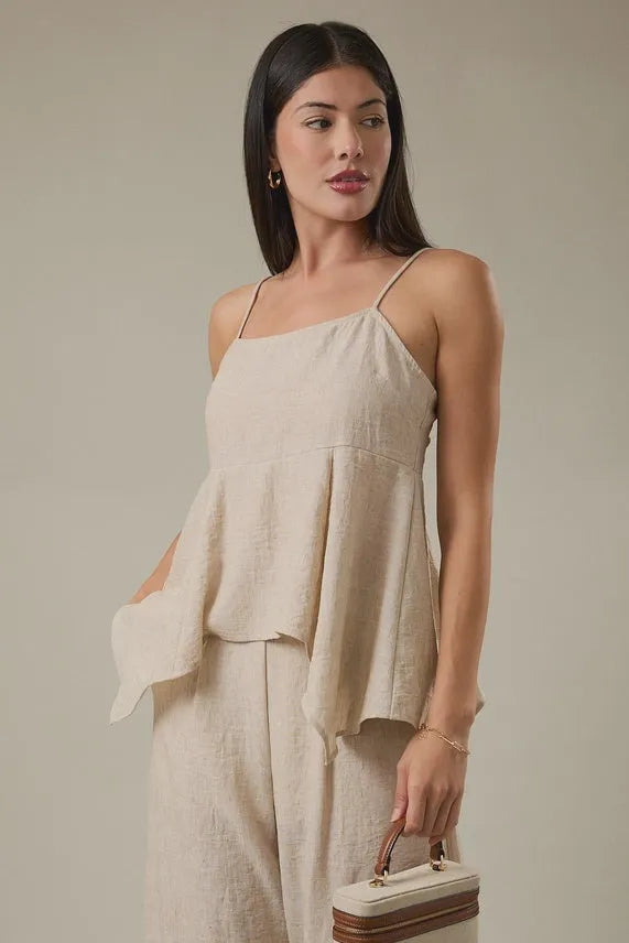Beige linen sleeveless back smocking hanky hem top with thin straps and flowing asymmetrical hem detail