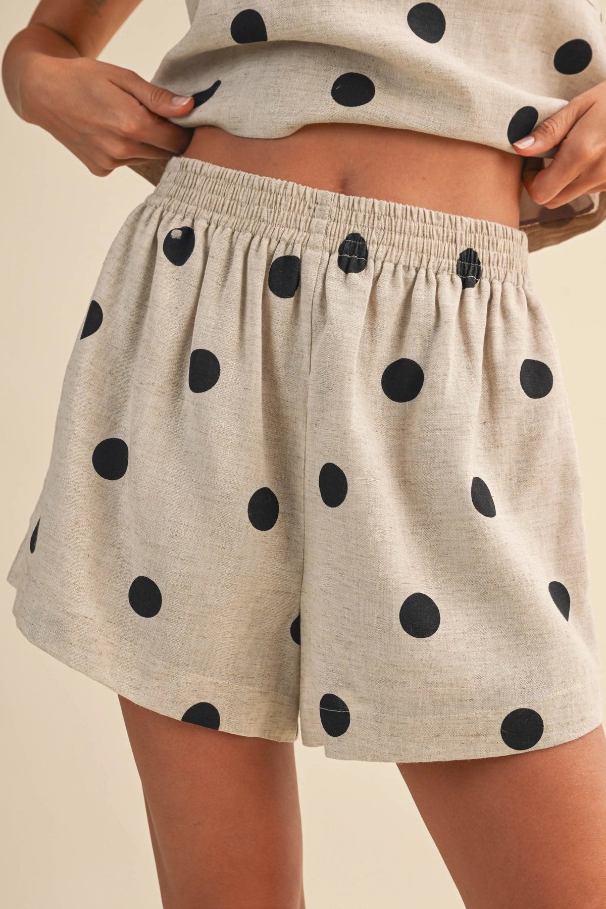 Beige polka dot linen short featuring black dots and an elastic waistband for comfortable wear