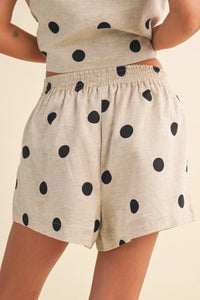 Beige polka dot linen shorts with an elastic waistband featuring black dots in a comfortable dot linen short design