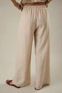 Beige linen wide leg pants with front pleat detail elastic waistband and relaxed textured fabric