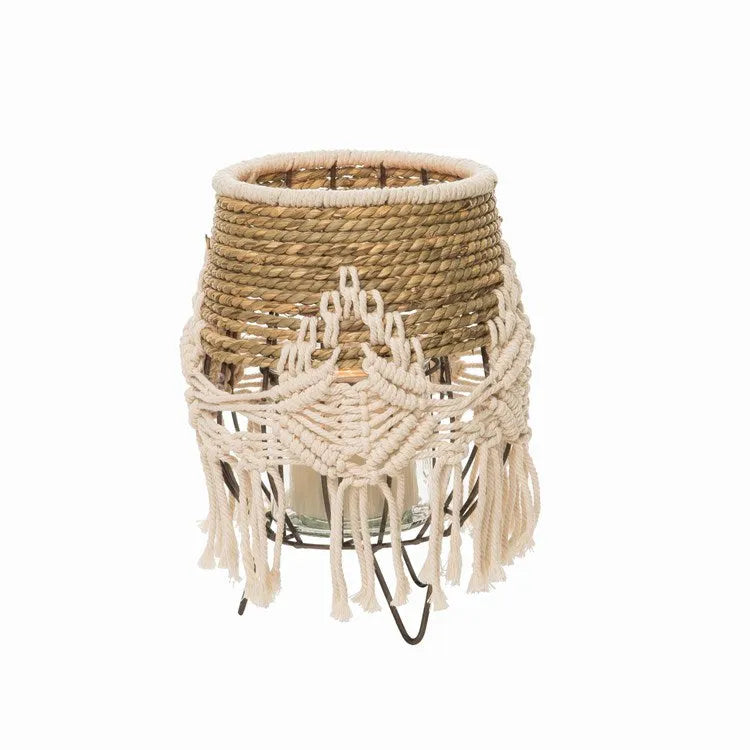 Beige macrame wrapped natural seagrass lantern with woven fiber base and fringe detailing for home decor