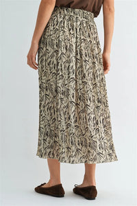 A flowing beige crinkle leaf print midi skirt with black leafy pattern and elastic waistband