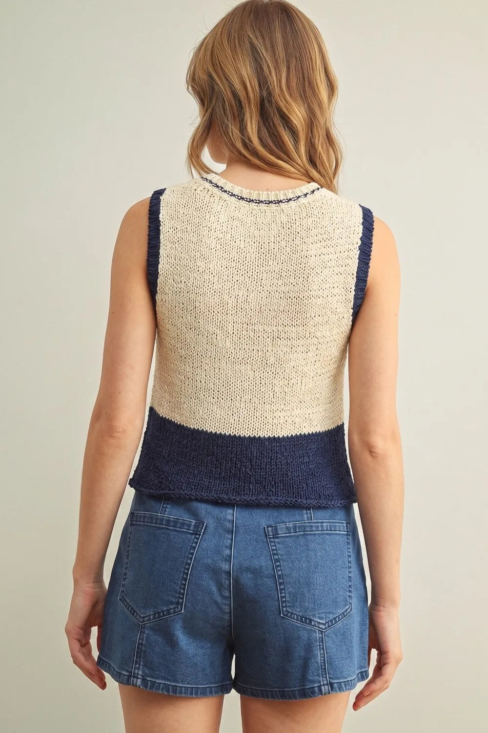Beige and navy blue color blocked sleeveless knitted top with textured knit pattern in a blocked sleeveless design