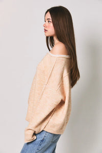 Beige off-the-shoulder knit sweater featuring a soft loose fit ribbed hem and contrast trim boat neck design