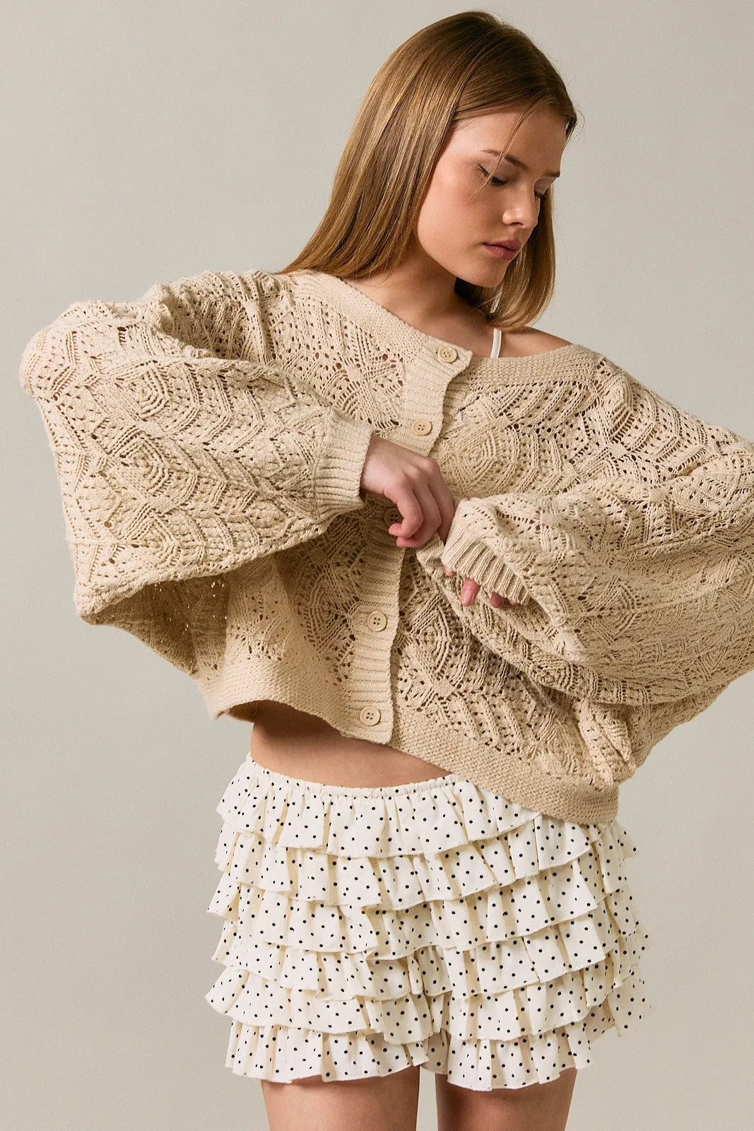 Beige long sleeve crochet cardigan featuring oversized knit with intricate cable and lace patterns
