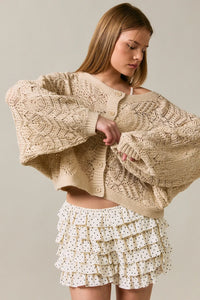 Beige long sleeve crochet cardigan featuring oversized knit with intricate cable and lace patterns
