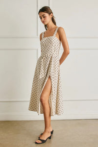 Beige polka dot linen midi dress with a square neckline, thin straps, and a buckle belt at the waist