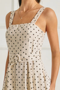 Beige polka dot linen midi dress with thin straps and a buckle belt featuring a circular buckle