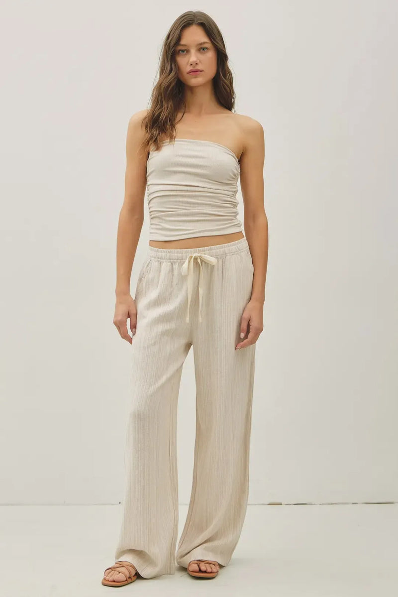 Beige ribbed strapless crop top paired with linen wide leg drawstring pants in a matching set for casual wear