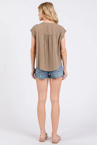 Beige short-sleeved pintuck detailed button down shirt with gathered back and relaxed fit shown from the back side