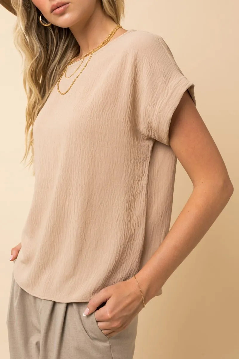 Beige short roll sleeve top with relaxed wrinkled texture and soft drape in women’s boho chic clothing by shop daisy
