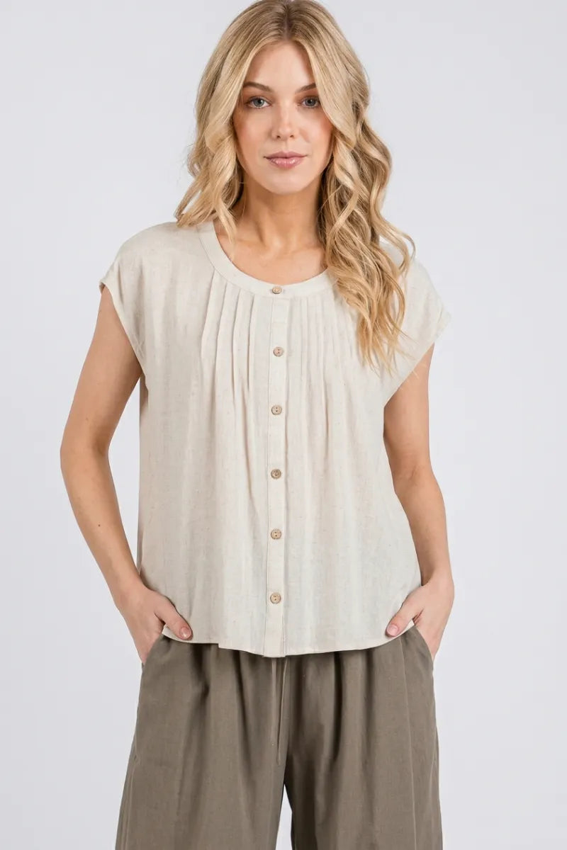 Beige sleeveless blouse featuring pintuck detailed button front closure and elegant pleated design