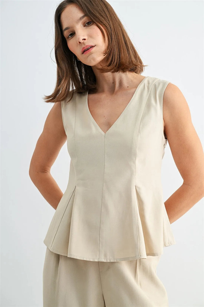 Beige v neck peplum sleeveless blouse with structured pleats at the hem for a stylish feminine look