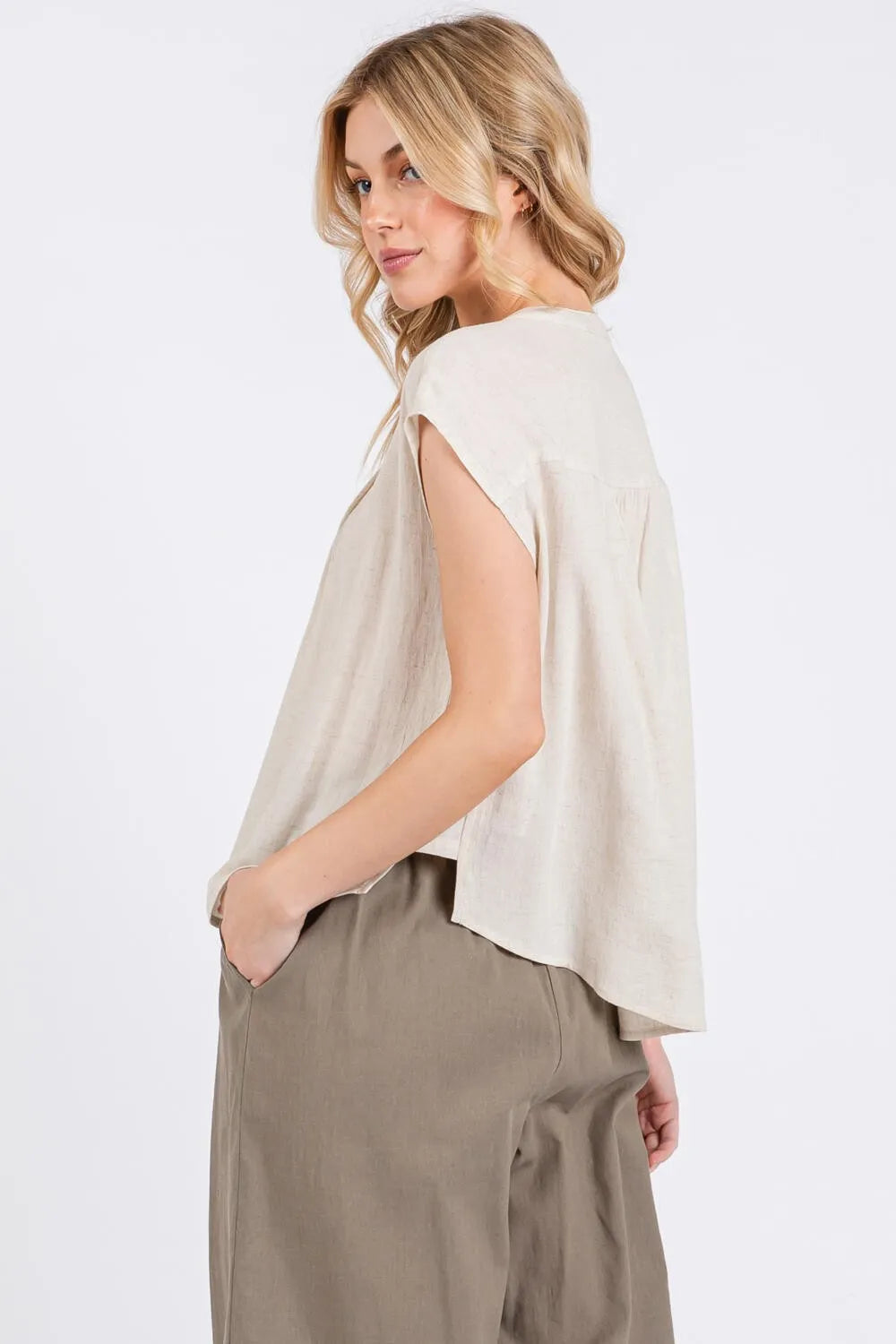 Beige sleeveless pintuck detailed button shirt with relaxed flowing silhouette and subtle side seam detailing