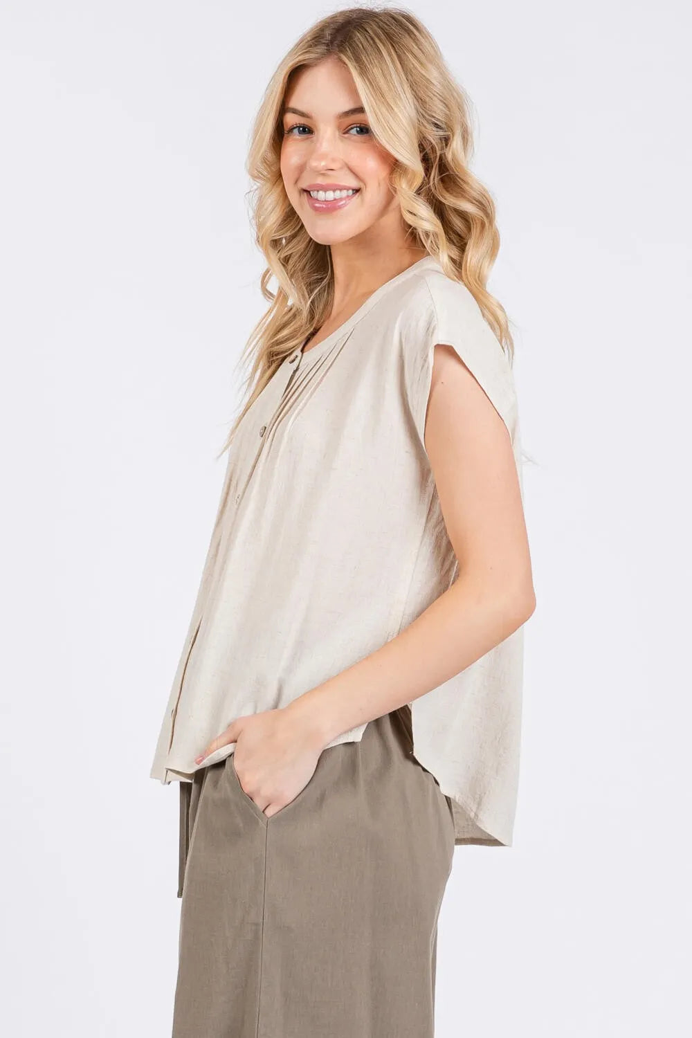 Beige sleeveless top with a relaxed draped silhouette and subtle front pintuck detailed button pleats
