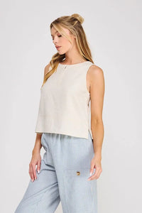 Beige linen button collar sleeveless top with subtle front zipper and side slits in textured fabric