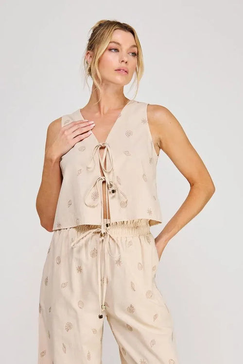 Beige seashell lace embroidered woven sleeveless top with v-neck and front tie featuring sea-inspired motifs