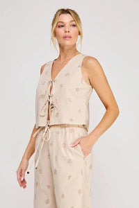 Beige seashell lace embroidered woven sleeveless top with v-neck and front tie featuring subtle leaf patterns