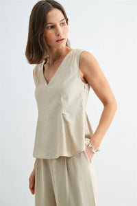 Beige v neck peplum sleeveless blouse with subtle front pleats for elegant and versatile wear