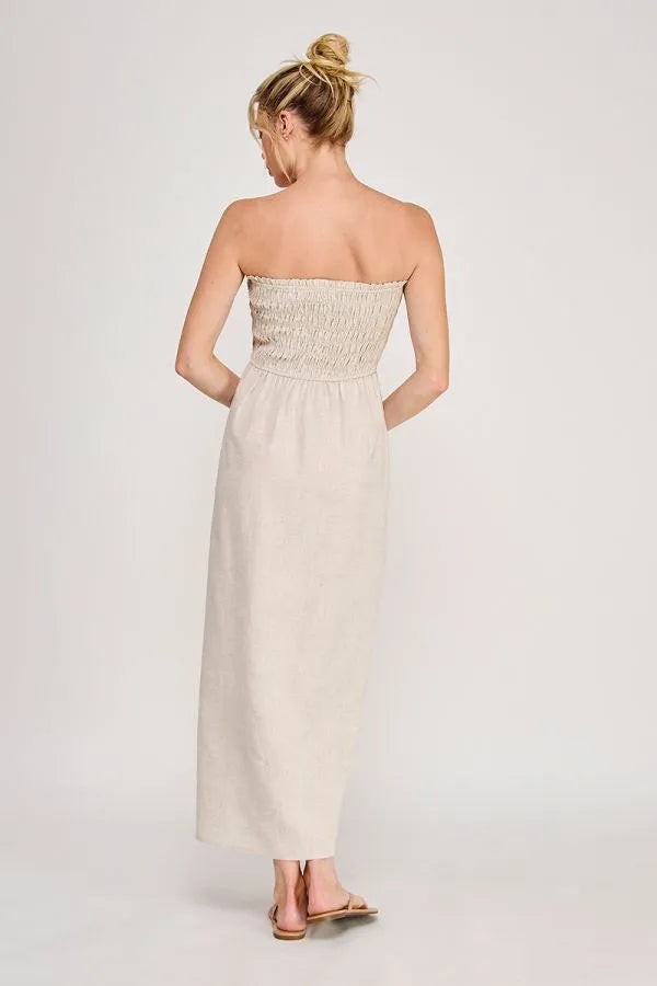 Beige strapless maxi dress with smocked bodice and flowing fabric featuring convenient side pockets maxi dress