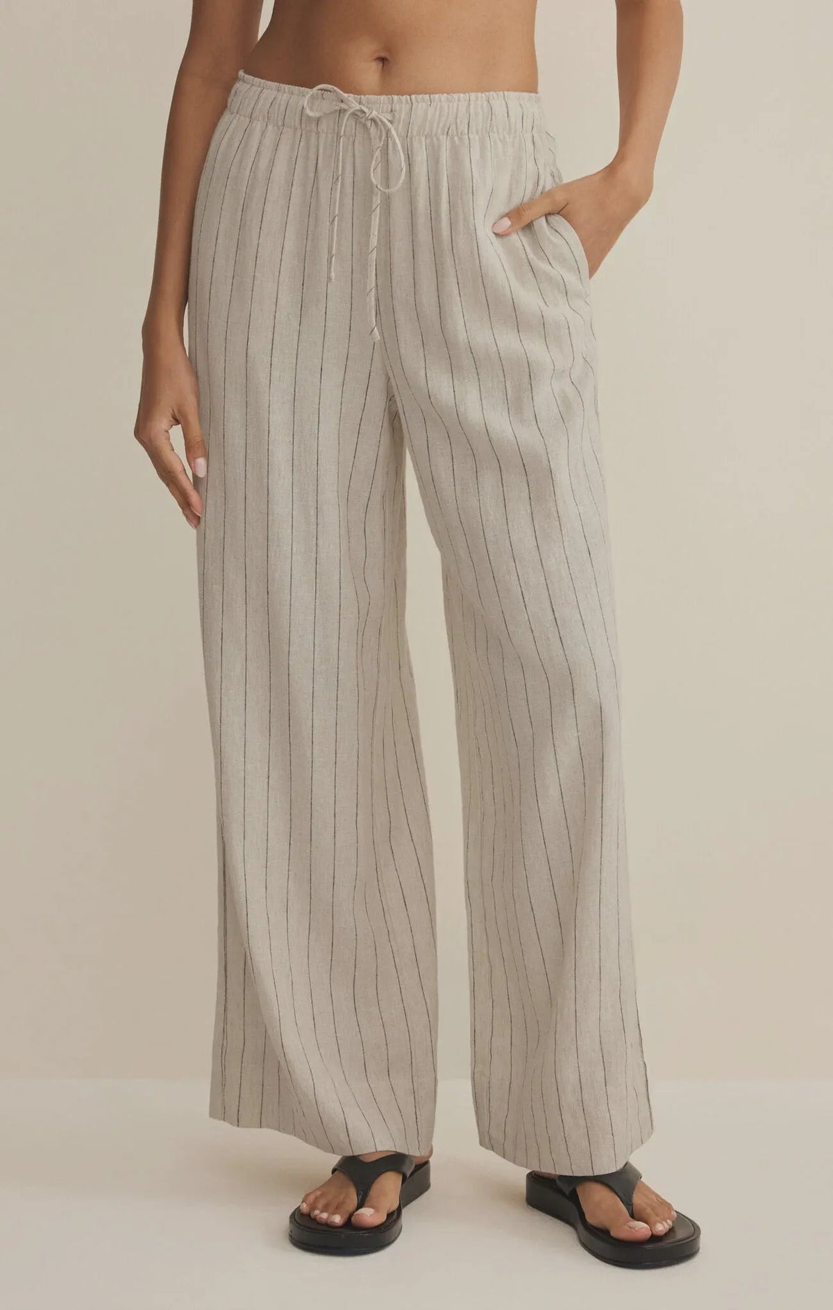 Beige and white vertically striped henri striped wide leg pants with elastic waistband and drawstring closure