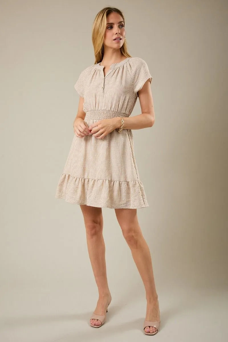 Beige and white vertically striped mini dress with notch neck short sleeves smocked waistband and tiered skirt