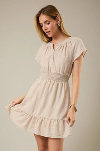 Beige and white striped mini dress with notch neck short sleeves, smocked waistband, and ruffled hem
