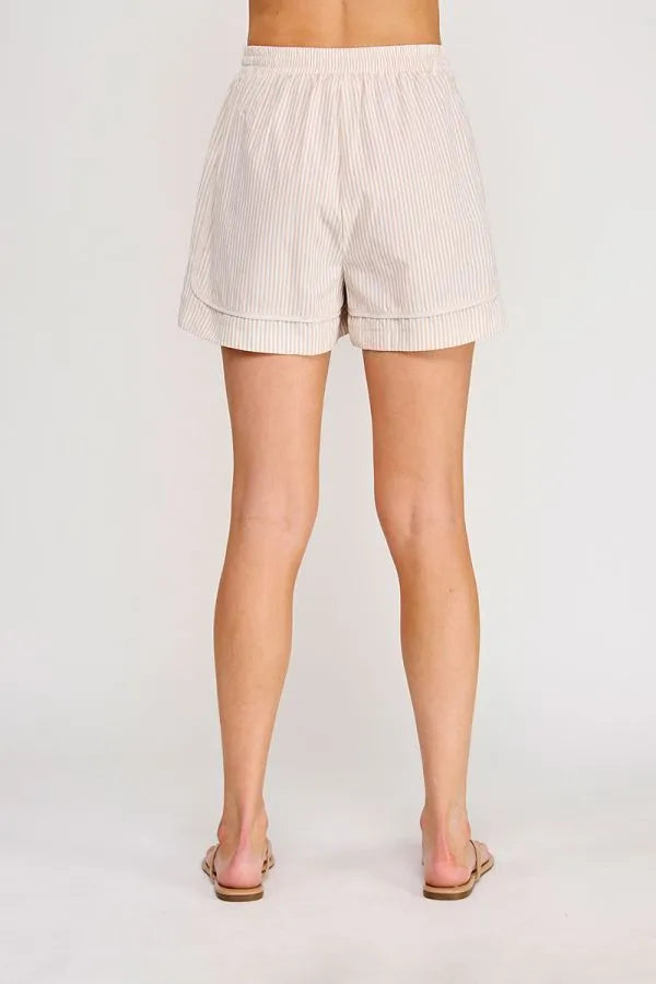 Beige and white vertically striped cotton shorts with rolled cuffs featuring a tie elastic waist and elastic waist pockets
