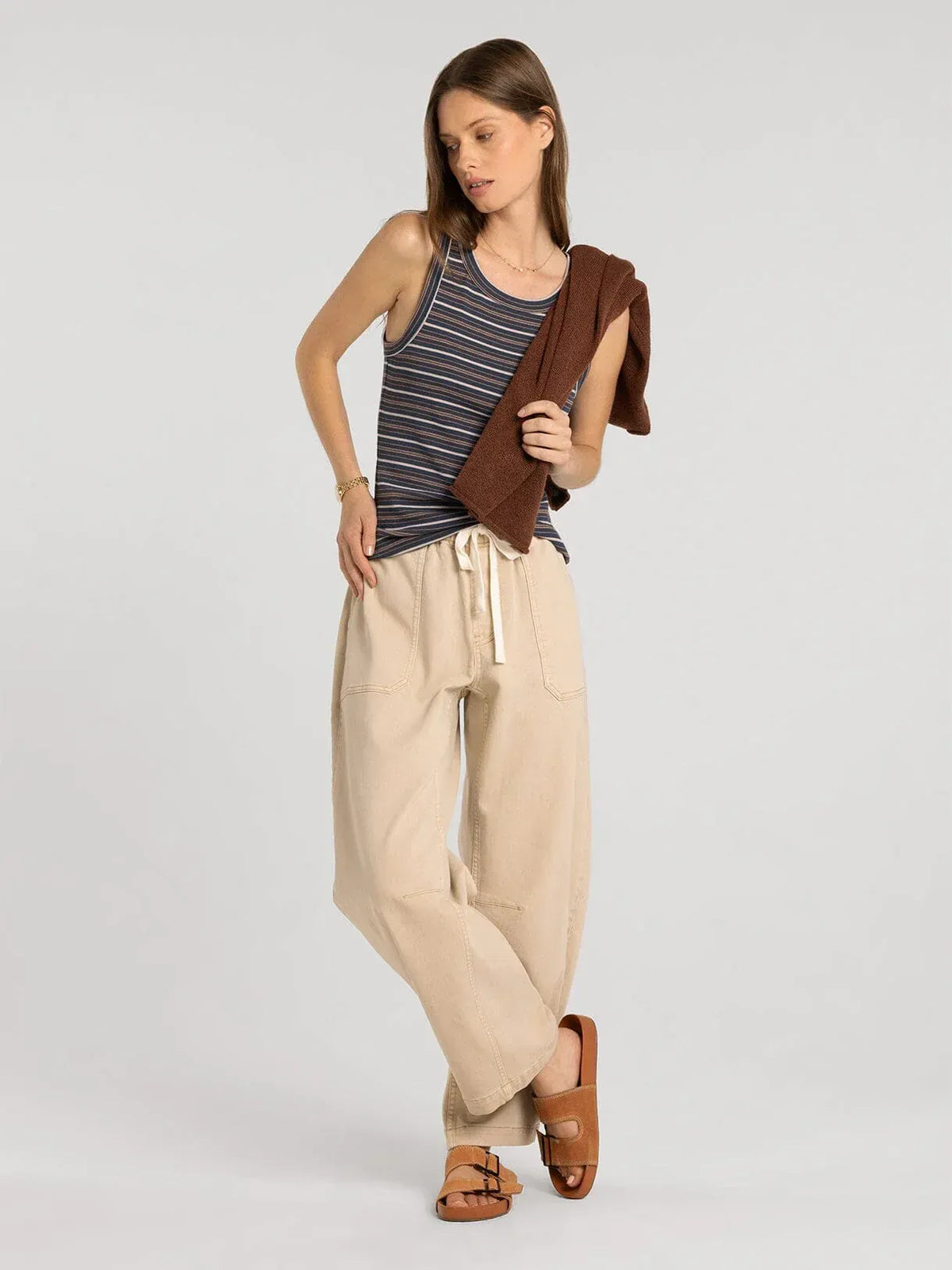 Beige wide-leg drawstring pants with side pockets and relaxed fit paired with thread and supply edlin basic tank