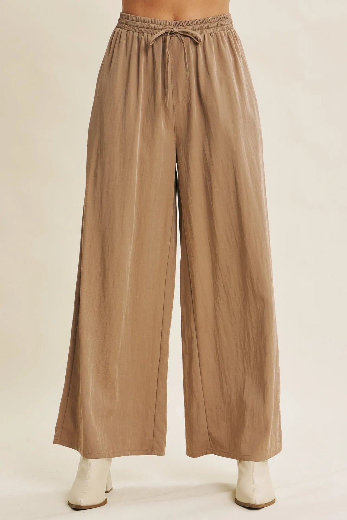 Beige wide leg pants with elastic waistband and drawstring in a step washed fabric for comfortable wear