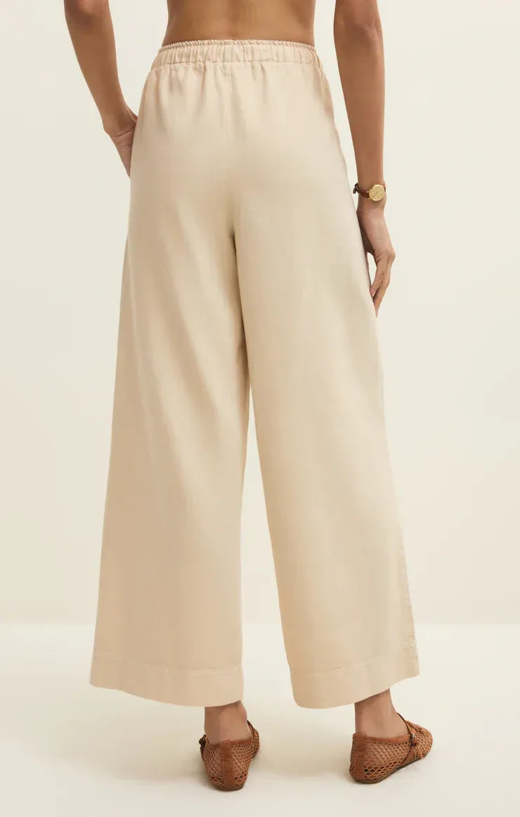Beige twill wide leg utility pants with elastic waistband and relaxed flowing silhouette