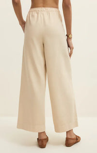 Beige twill wide leg utility pants with elastic waistband and relaxed flowing silhouette