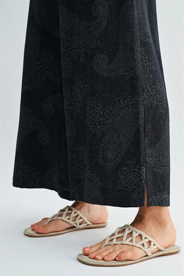 Beige woven strap thong sandals with flat sole paired with paisley printed elastic waist pants for casual wear