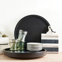 Black circular serving tray with smooth matte finish and raised edges from everyday luster glass green collection