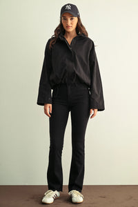 Black cropped bomber jacket with bell sleeves and zipper front styled with ladies slim bootcut jeans for a modern look