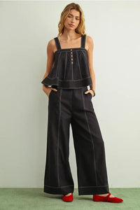 Black denim jumpsuit with white stitch detailed sleeveless design and button details for stylish wear